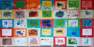 Photograph of children's paintings displayed on wall at Starting Point Montessori School